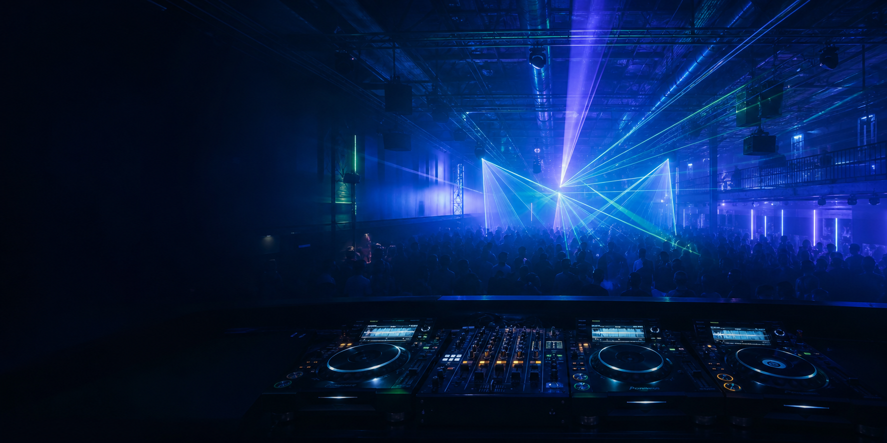Nightclub lights and dance floor viewed from behind the DJ booth