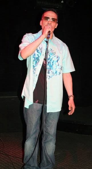 Ray Velarde singing into a microphone on stage